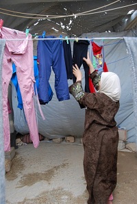 Kuuden lapsen äiti Zaka'a Al-Madrood on jo vuoden ajan pessyt pyykit käsin. Hän sanoo tarvitsevansa kipeästi pesukonetta. Hänen puolisonsa ei halunnut, että vaimon kasvot näkyisivät valokuvassa.