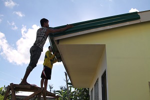 Felomino Cabueños (left) and Nilboy Ocale setting up gutters at the San Jose School new classroom.