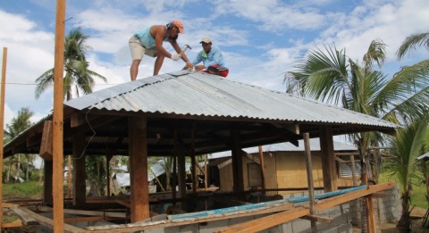 Servando Alliabas (left) and Joel Abeleno are constructing in Samar-island a four-cornered roof, which has proven resistant to strong winds.