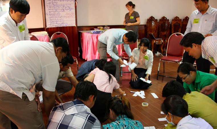 In the training, teachers and officials from the Ministry of Education and districts are studying together, which is uncommon in Cambodia. In the background, Vichet Un and Theary Chhoeun are concentrating on a group assignment.