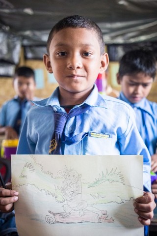 Suresh Tamang, 10 years old, is an aspiring young artist. He is showing his drawing of a beaver.