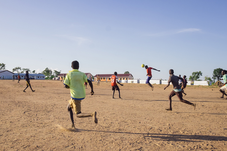 Mycket av livet bland de sydsudanesiska flyktingarna kretsar kring barnen. Av en miljon flyktingar är över 60 procent under 18-åringar. Bilden är tagen på fotbollsplanen vid Kyrkans Utlandshjälps skola som ligger på andra sidan vägen från Muja Roses lerhydda.