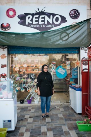 Ranaa stands in front of her shop.