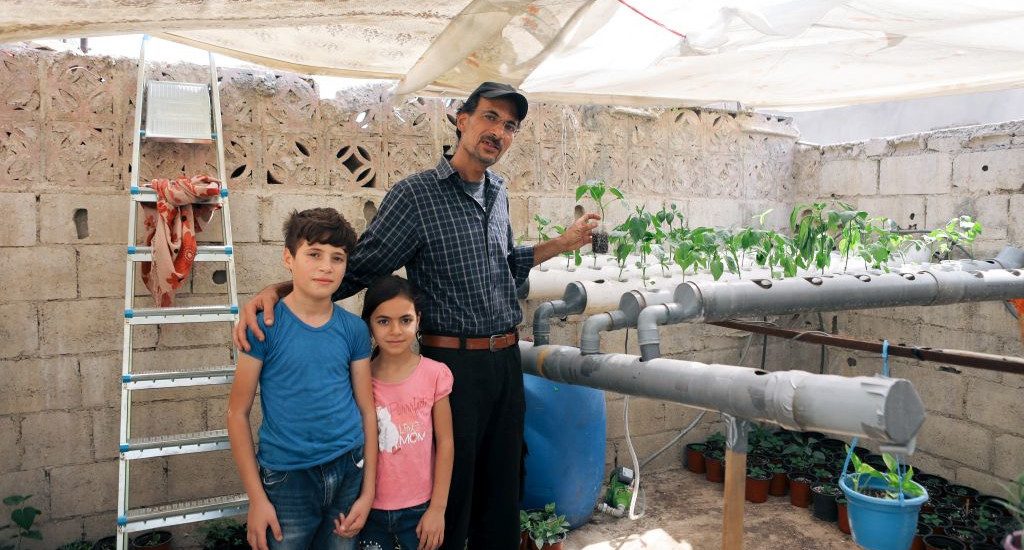 Ibrahim Milhem, hänen tyttärensä Layal Milhem ja hänen poikansa Forat kasvihuoneessa.