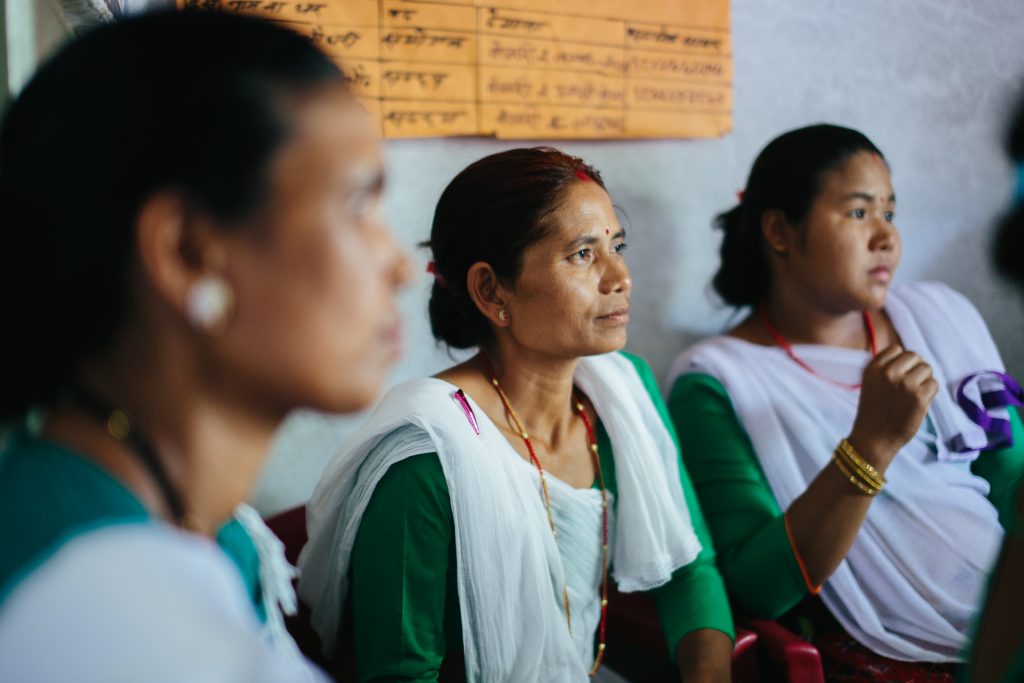 Three women listen to something.