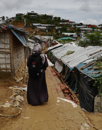 Tamara walking through camp on her way to a home-based learning session.