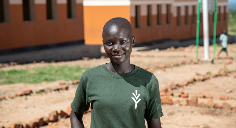 Sharon seisoo koulunsa edustalla Bidibidin pakolaisasutusalueella Ugandassa.