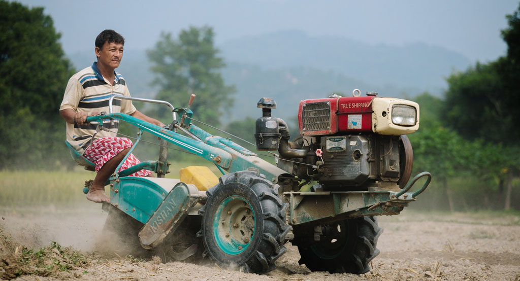 Nepalilainen Khincha Lal Pahari ajaa traktorilla pellolla.