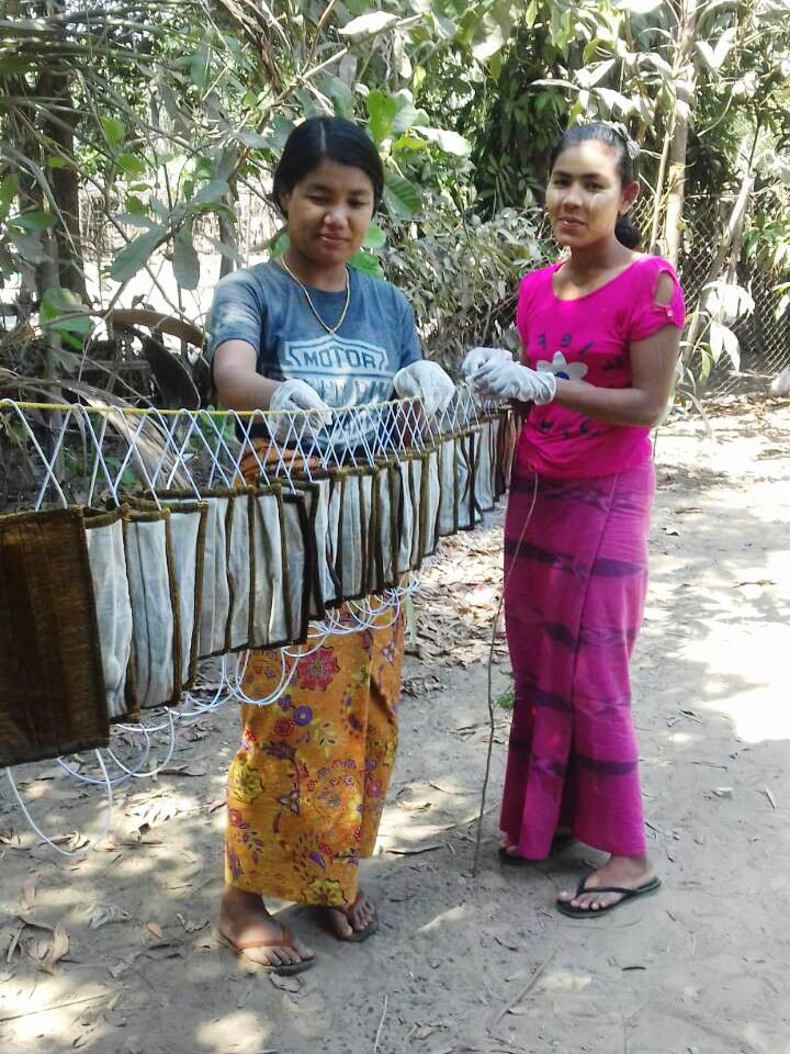 Myanmarilaisia ompelijoita valmiiden hengityssuojaimien kanssa.