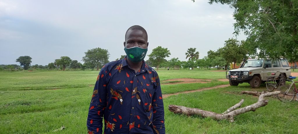 A man standing in front of a field.