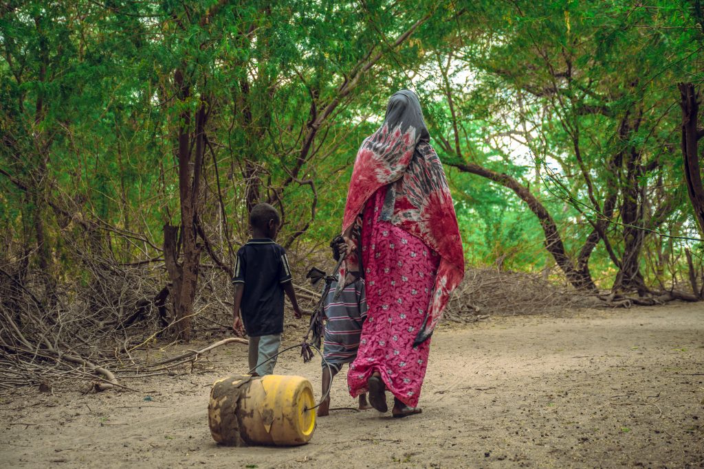 woman and children dragging a jerrycan_fca kenya