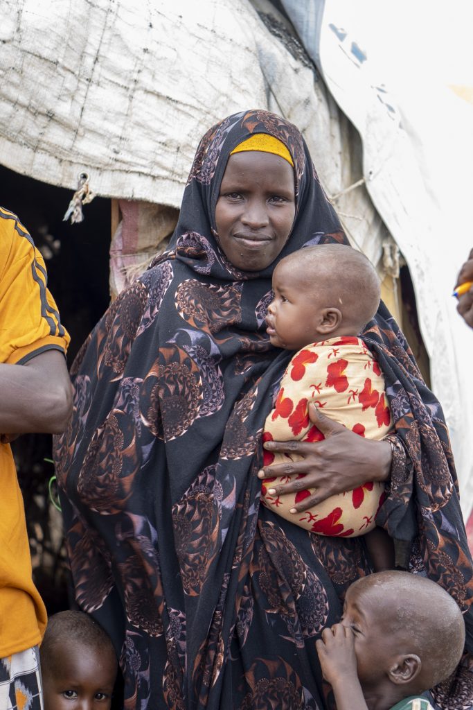 Somalinainen pitää sylissään vauvaa. Kuvassa myös toinen lapsi.