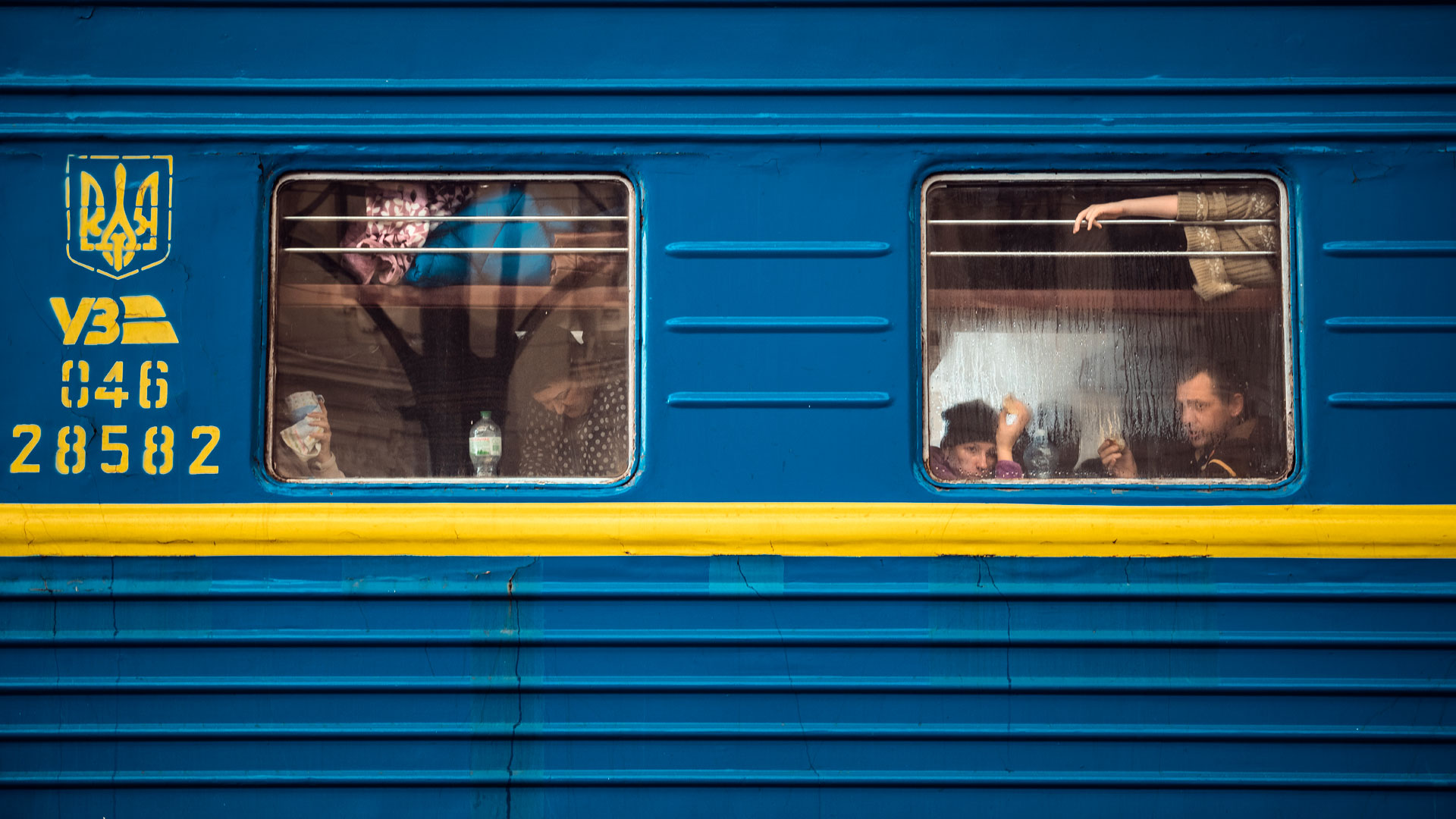 Junan kylki. Ikkunoiden takana näkyy junassa istuvia ihmisiä.