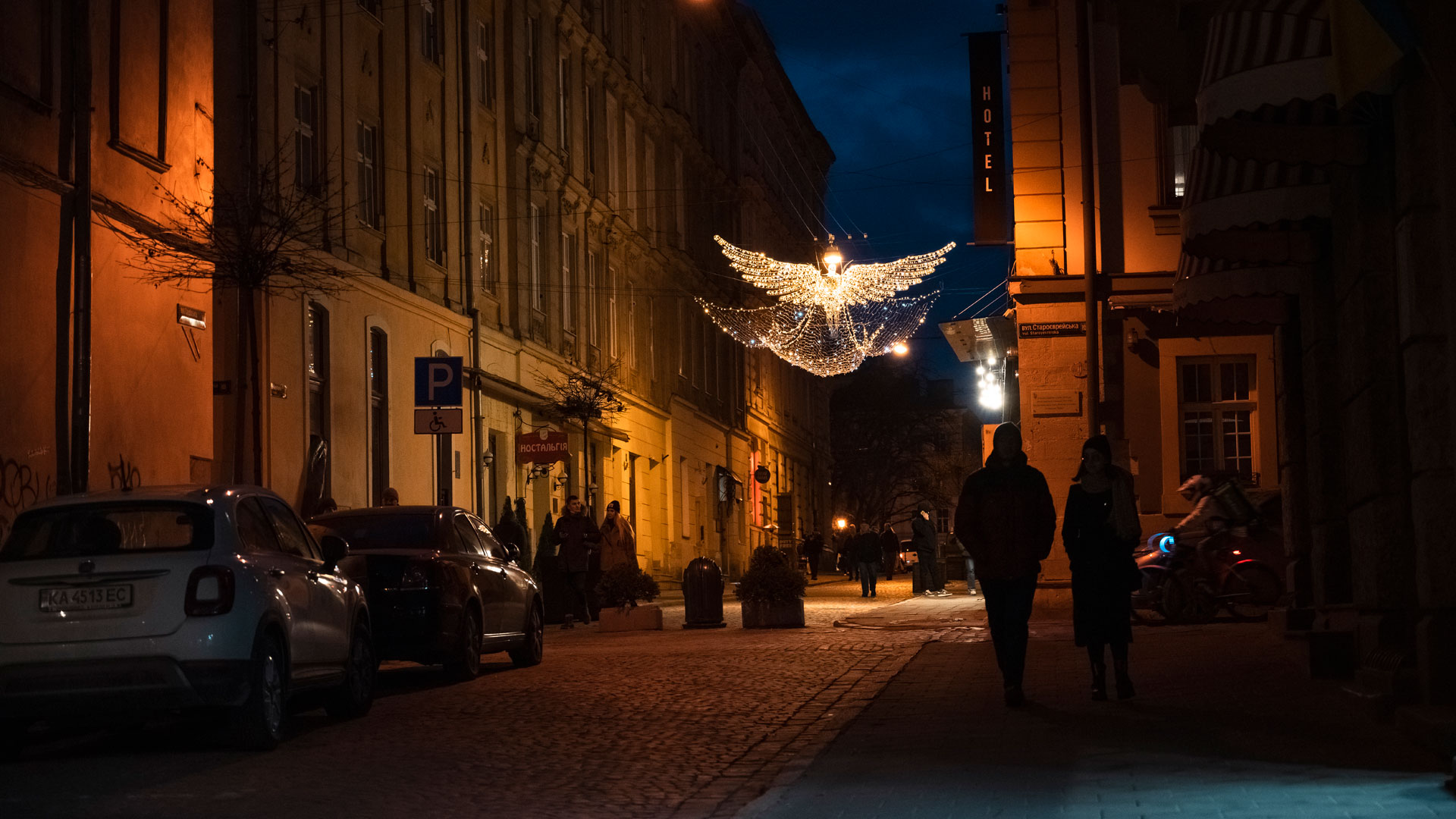 öinen katunäkymä. Taustalla näkyy kadun yli levittäytyvä jouluvalo.