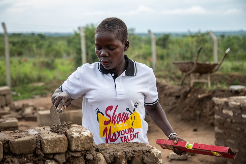 A woman laying bricks in Uganda. 