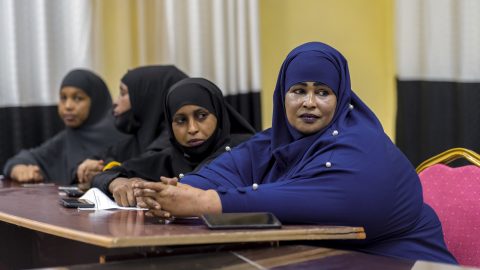 Neljä naista istuu pöydän äärellä rivissä Somaliassa. Naisista kaksi etummaista katsoo kameraan päin.