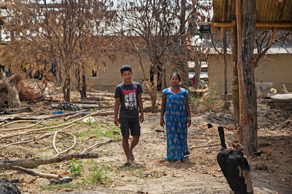 A man and an older woman walking in a village in Nepal. 