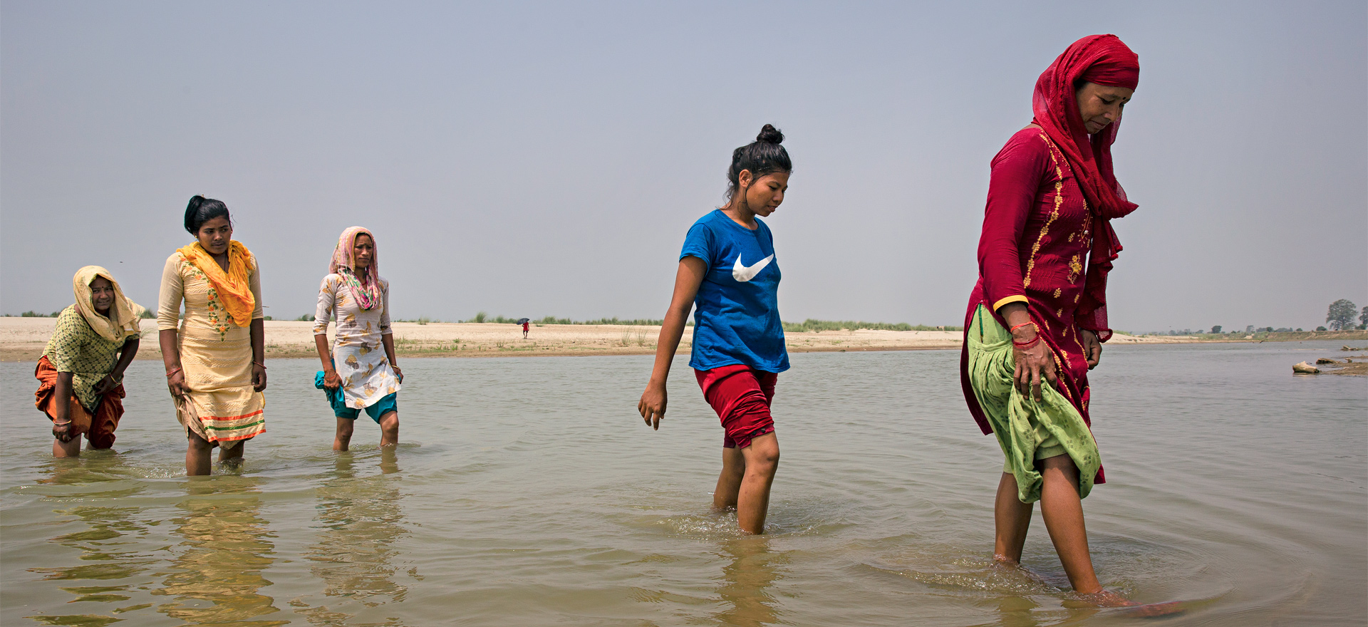 Viisi naista kahlaa vedessä Nepalissa. Kuva: Uma Bista