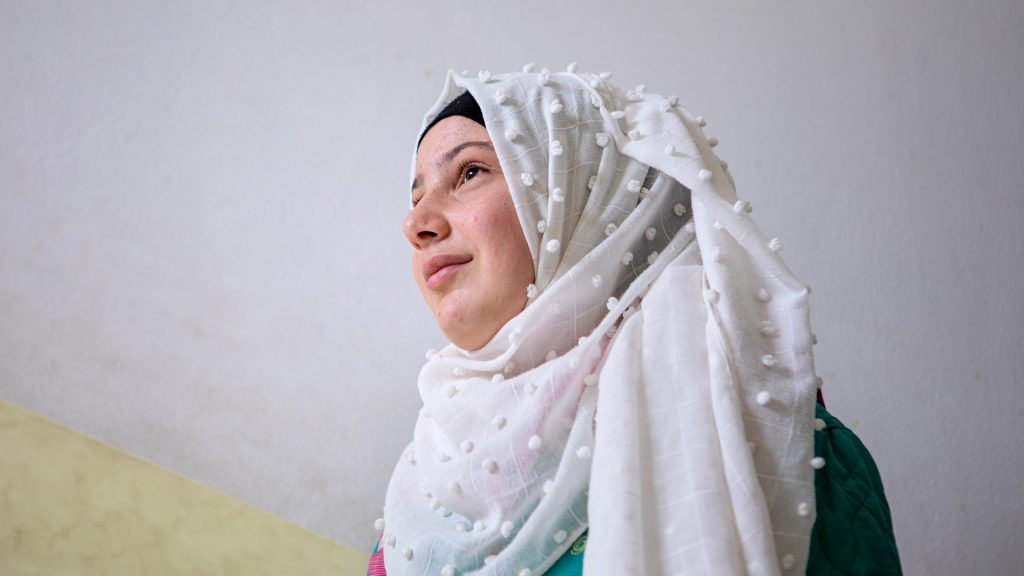 Syrian flicka fotograferad framför vita väggan. 