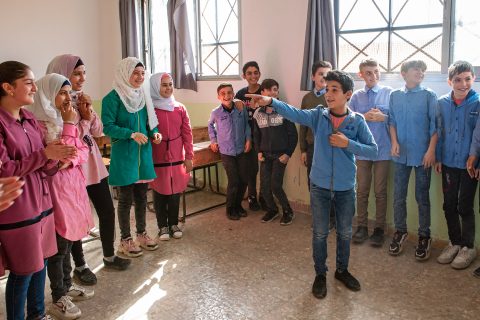 Joukko tyttöjä ja poikia seisoo rivissä luokkahuoneessa Syyriassa. Kuva: Erik Nyström
