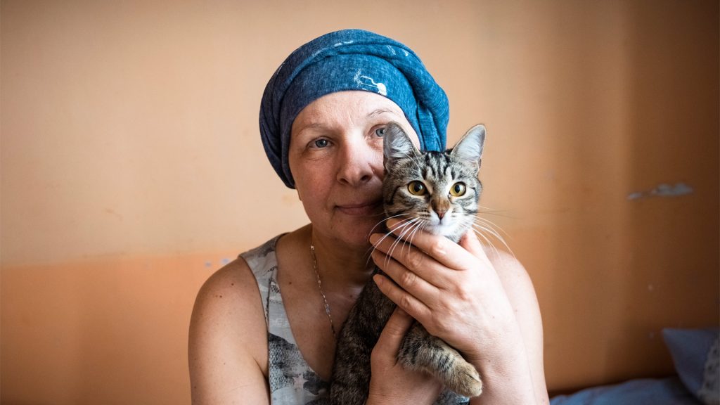 A women in a headscarf holds a cat