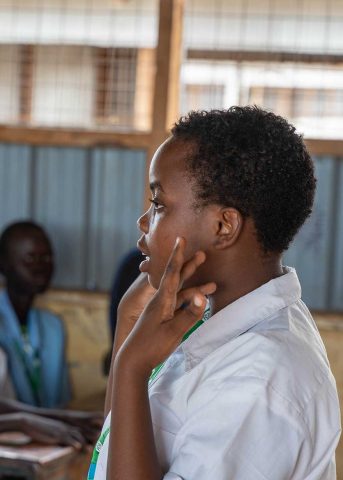 A Burundian school girl speaks in front of a class.