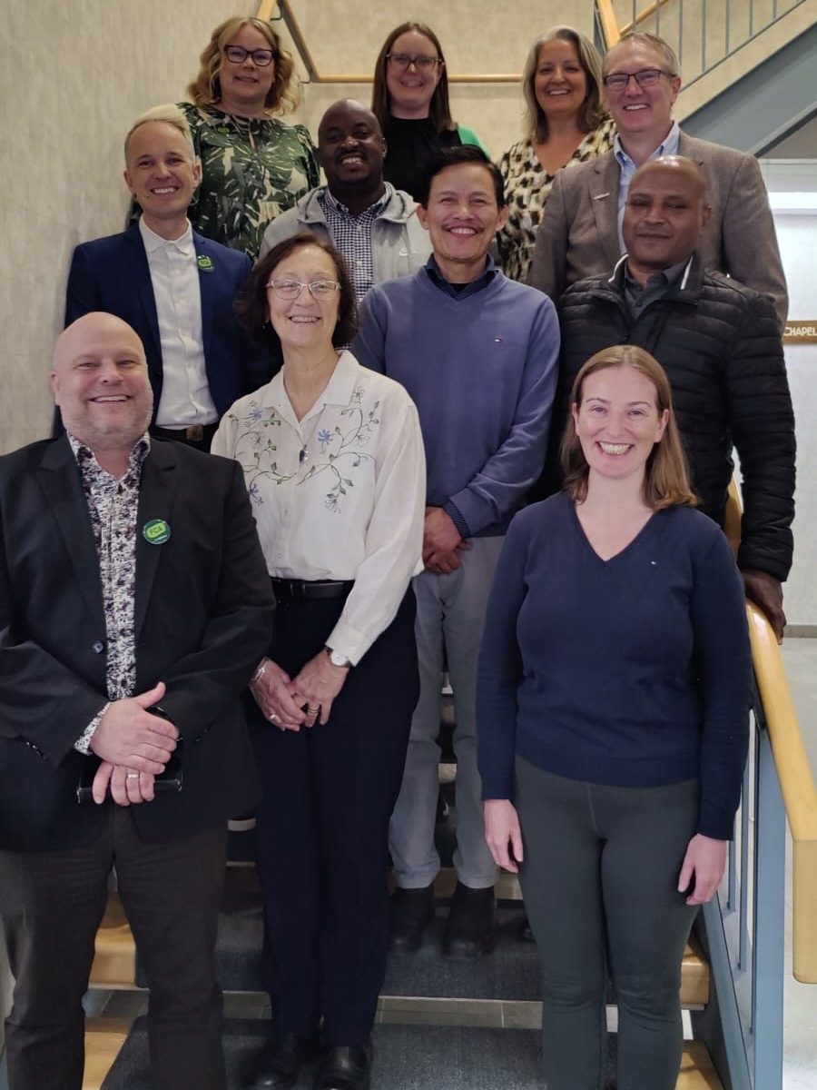 A number of smiling people pose for a photo on a staircase