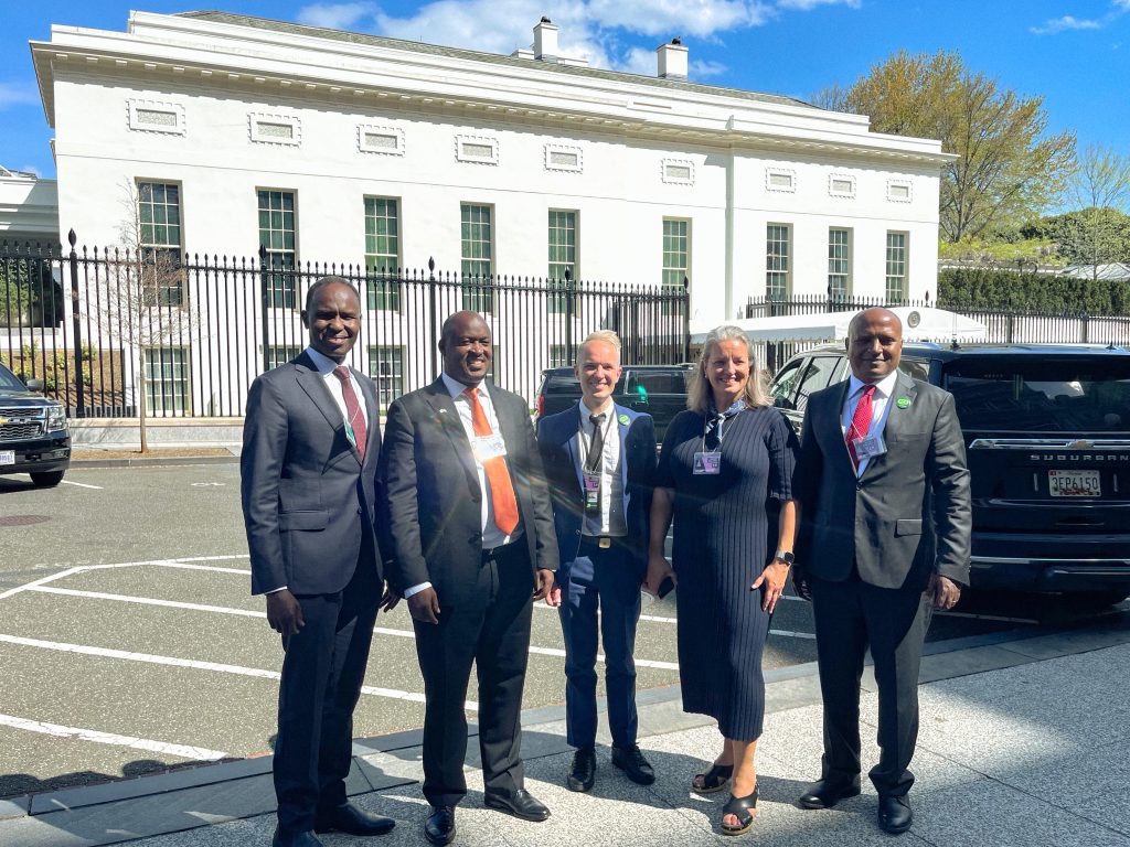 Five people pose for a photo in a car park in front of the White House in Washington, DC, USA