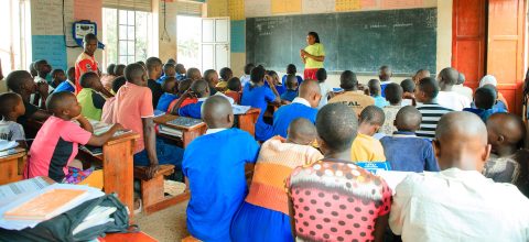 A teacher talking to a crowded classroom