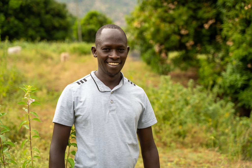 A man standing in front of a field.