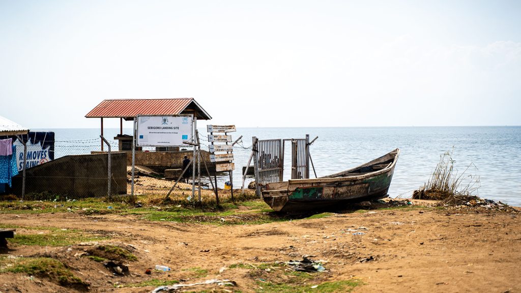 A boat on.a shore next to a lake