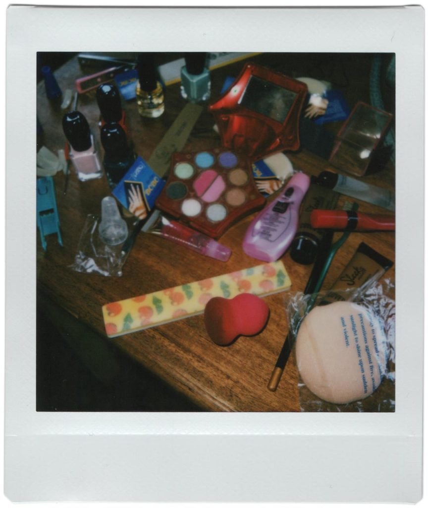 A polaroid photo of various make up on a table.