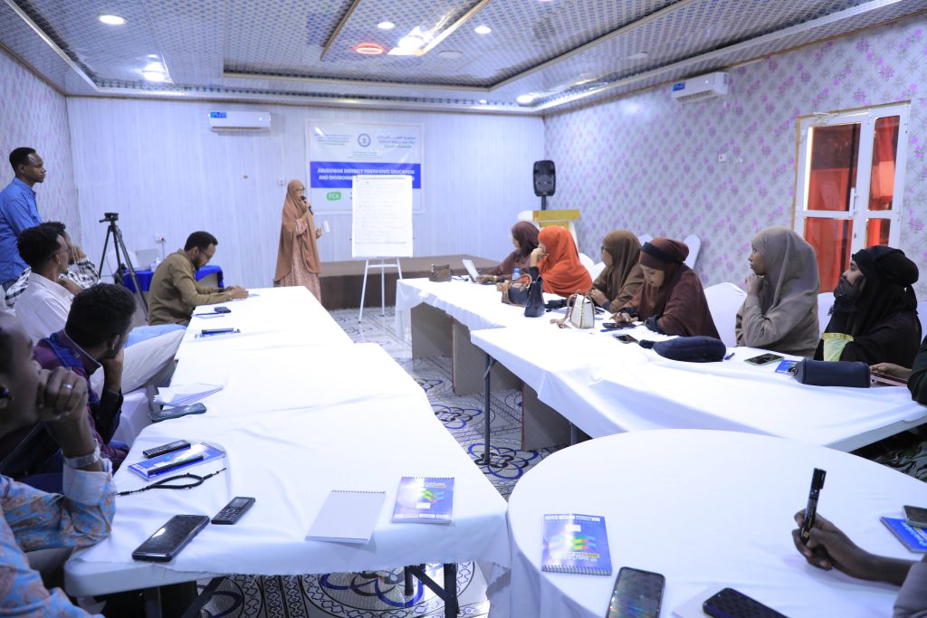 A meeting room with a meeting led by a woman and with mostly woman participants in the photo