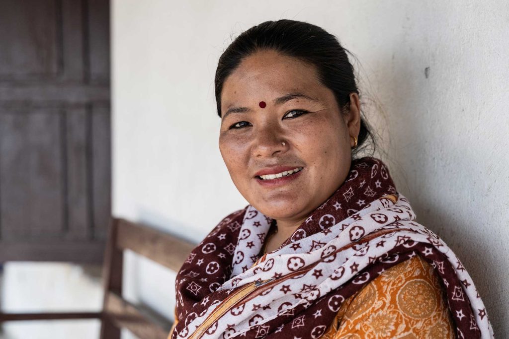 Nepalilainen nainen hymyilee kameralle.