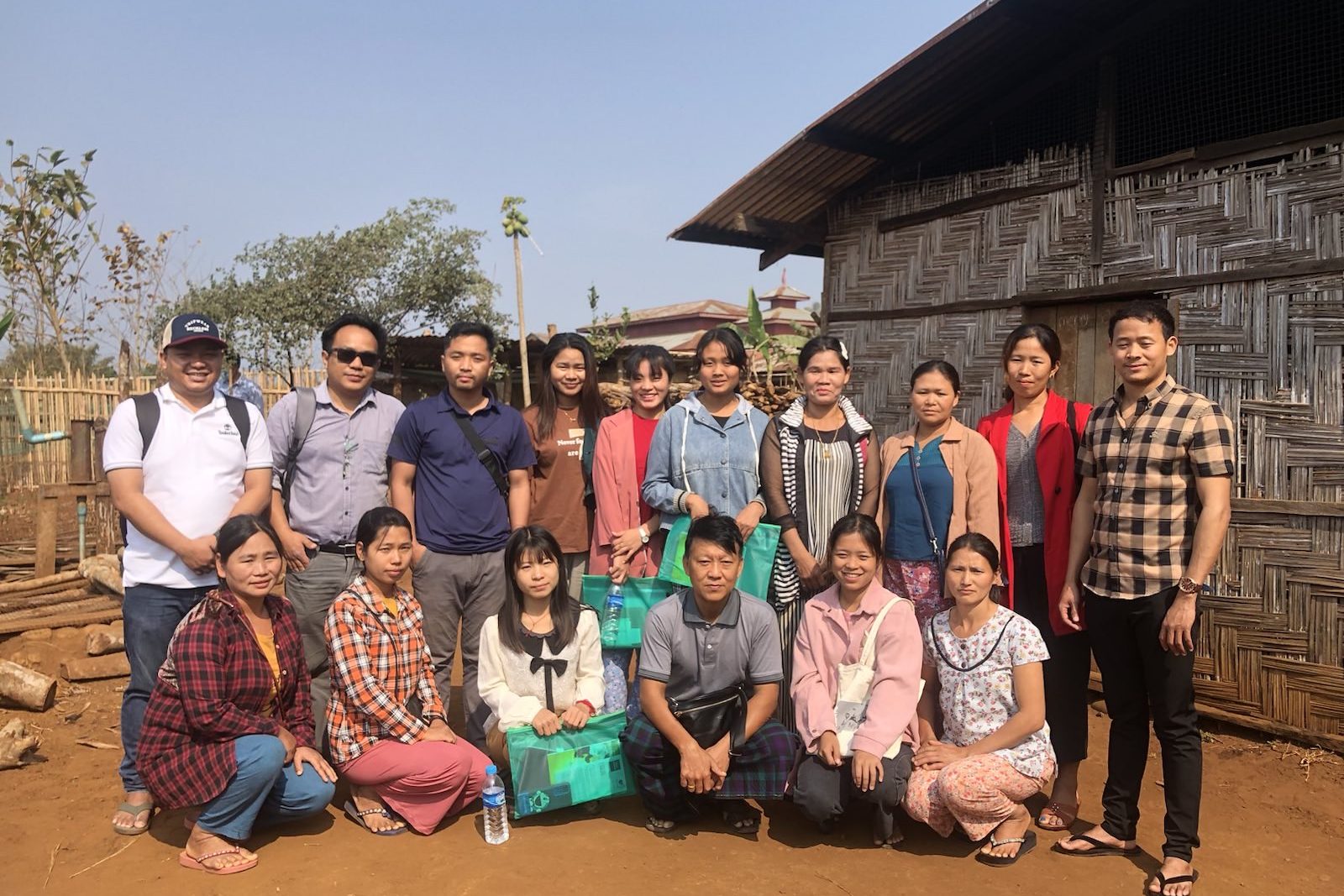 A group of men and women pose outside for a photo