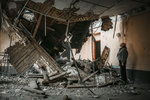 A woman looks at the ceiling of a classroom destroyed by a missile strike in Ukraine/ Nainen katsoo Ukrainassa ohjusiskussa tuhoutuneen luokkahuoneen kattoa.