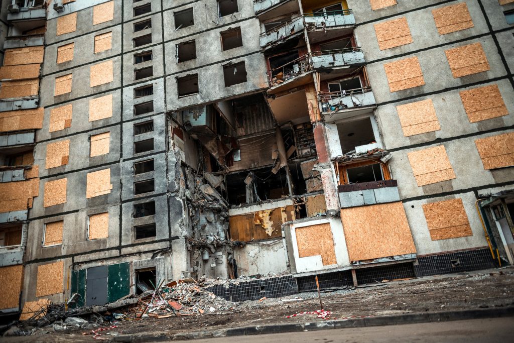 Ohjus on iskenyt kerrostaloon Ukrainassa. Kerrostalon ehjäksi jääneet ikkunat on suojattu vanerilevyillä.