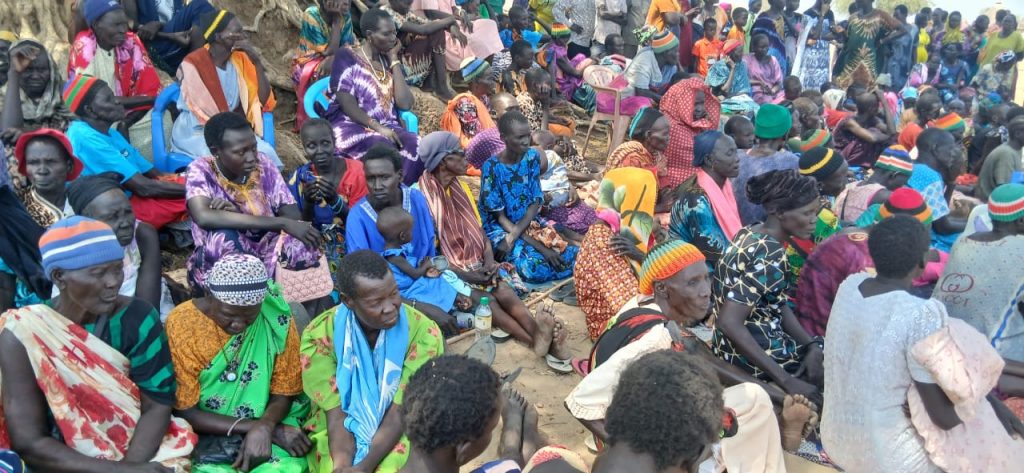 A large group of people sitting on the ground