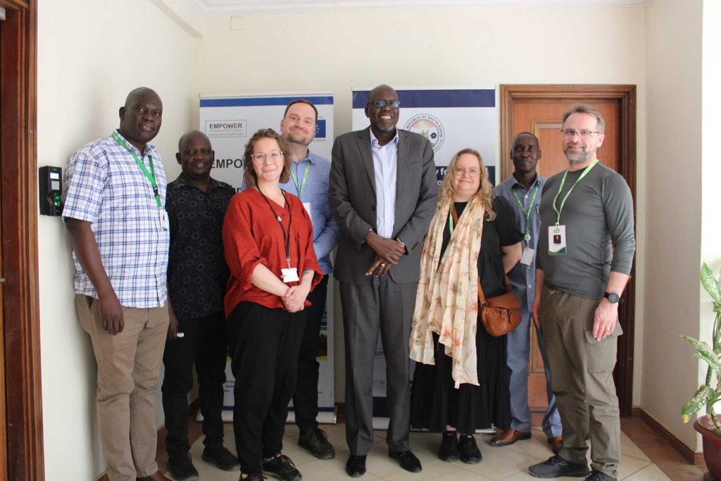 Ryhmä ihmisiä poseeraa sisätiloissa valokuvassa.