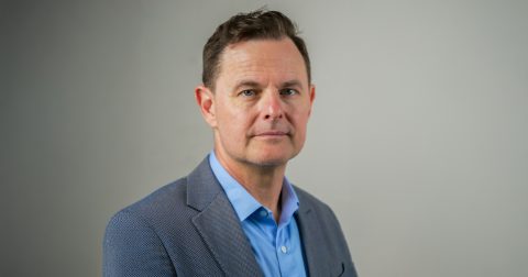 A portrait photo of a man in a suit.