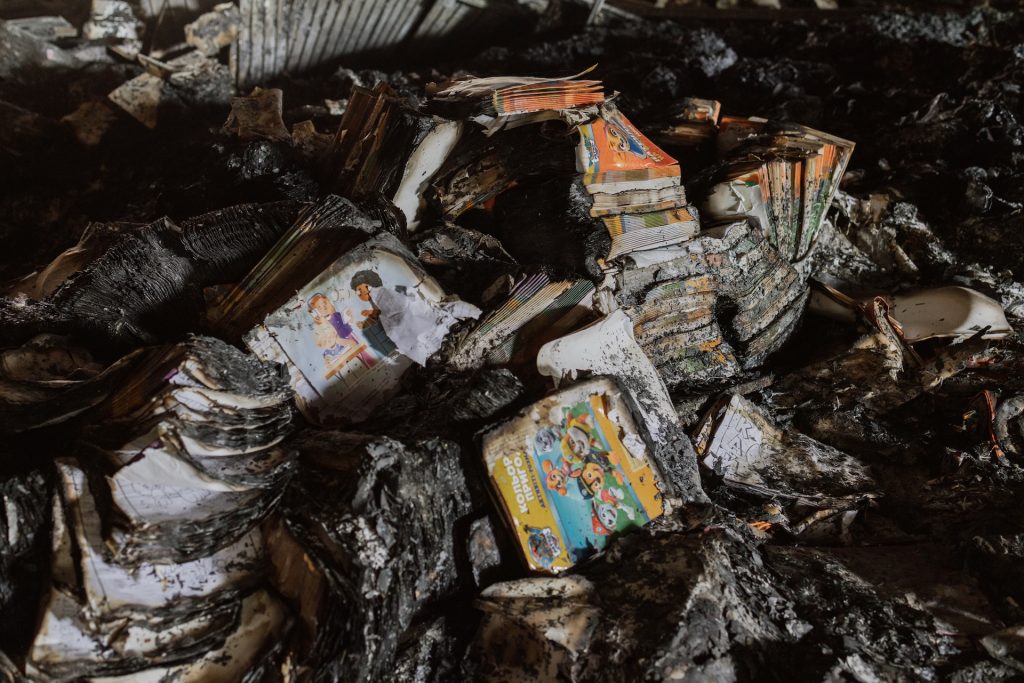 A pile of charred books in a warehouse