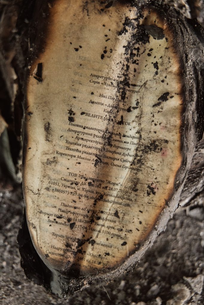 A close-up of a charred page from a book showing Ukrainian text