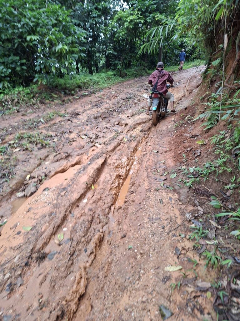 A motorbike travels along a muddy track.